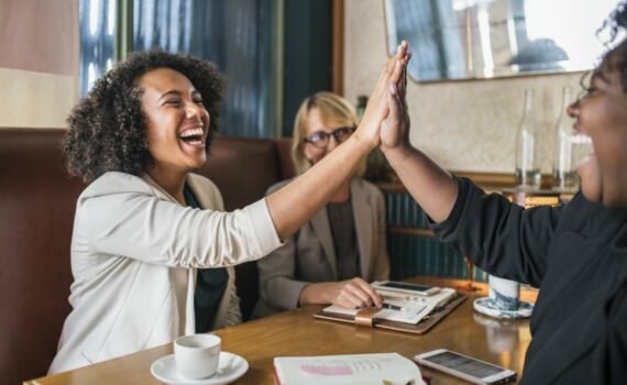 laughing-people-giving-high-five-in-the-cafe