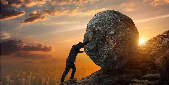 man pushing boulder uphill